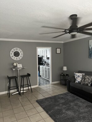 Relax in this stylish living room with a sofa, rug, and ceiling fan.