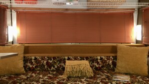 Ein gemütliches Interieur mit einer Couch, einem herzförmigen Kissen und einem gewebten Korb auf einem Regal.