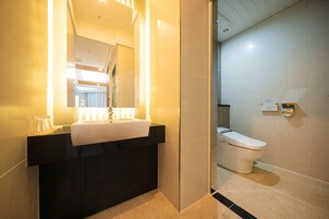 Casa de banho moderna com toucador preto, lavatório branco e sanita.