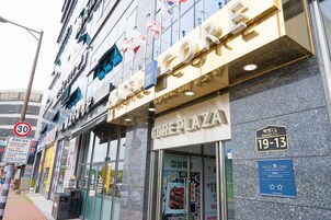 Um hotel chamado 'Core Plaza' com uma placa indicando os números de quartos 19 a 13.