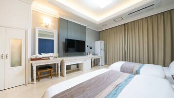 Una habitación de hotel con cama, escritorio, televisión y un minibar.