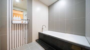 Un bagno moderno con una vasca da bagno ampia, una zona doccia e un portasacchi a righe.