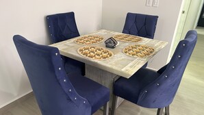 A dining table with four blue upholstered chairs, a woven placemat, and a decorative centerpiece. - Cozy 2-bedroom condo, located in the center of the city.  (Ciudad de México)