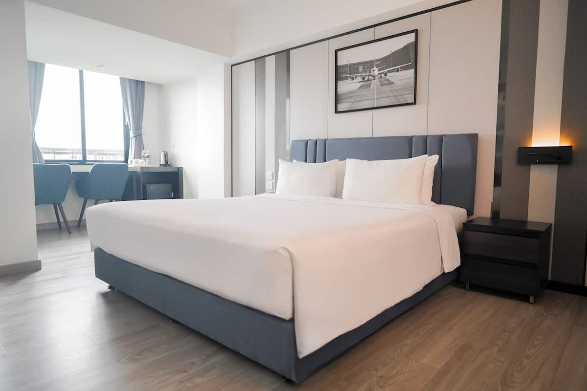 Une chambre d’hôtel moderne avec un grand lit, un bureau et une chaise.