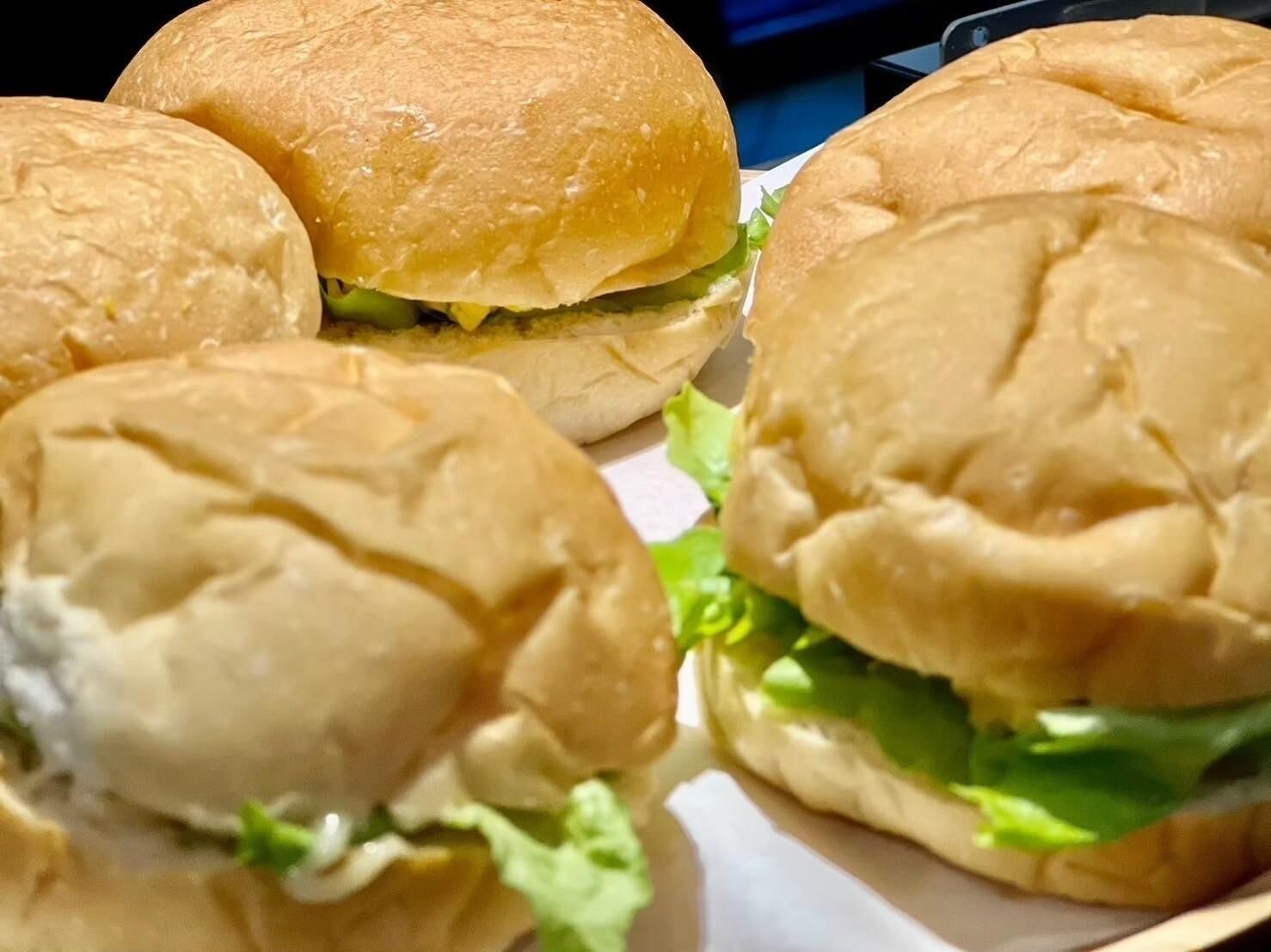 Primer plano de tres hamburguesas con lechuga y pan.