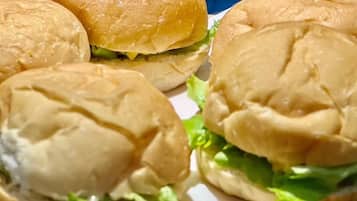 Primer plano de tres hamburguesas con lechuga y pan.