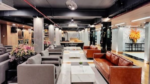 Un hall d’entrée moderne avec des canapés, une table basse et un comptoir d’accueil.