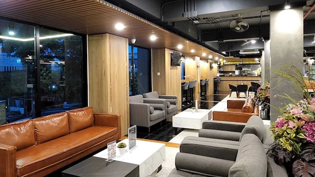 Un intérieur moderne avec des canapés en cuir, des tables blanches et des panneaux de bois.