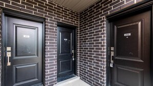 Three black doors with numbers 301, 302, and 202, set in a brick wall. - Elegant Apartment,  5mins from the Falls (Niagara Falls)