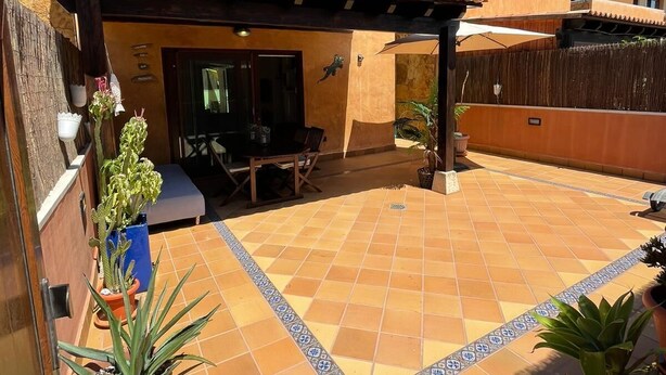 A courtyard with a tiled floor, outdoor seating, and potted plants. - Sunset Beach 4 Floor Villa 200m to Beach+Fast WIFI (Corralejo)