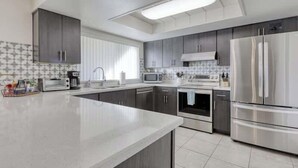 Una cocina moderna con armarios grises, electrodomésticos de acero inoxidable y una isla grande.