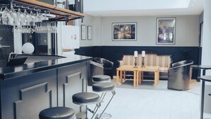 Una cocina moderna con barra, taburetes y mesa de comedor.