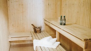 Una sauna de madera con bancos, una toalla y botellas de agua.