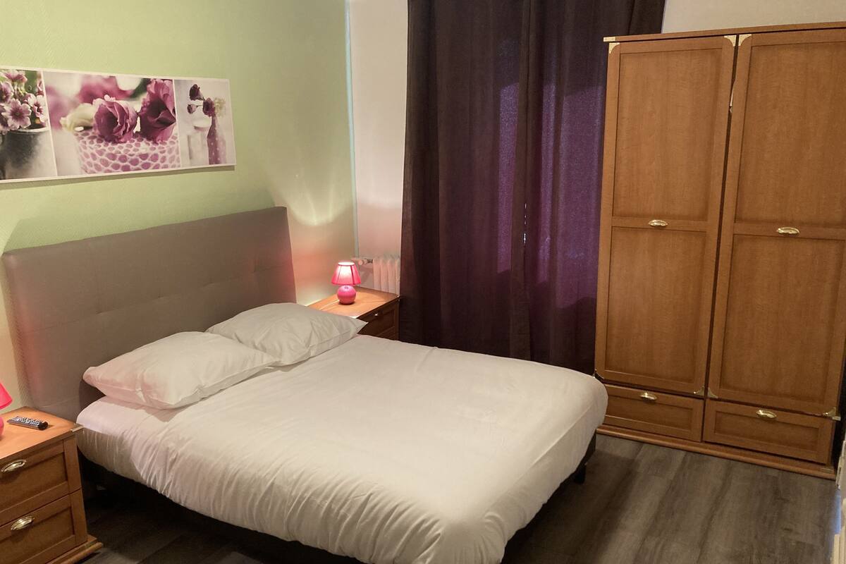 Ein Schlafzimmer mit Bett, Nachttisch, Lampe und Holzschrank.