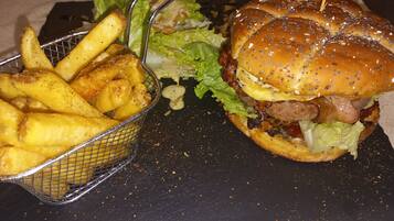 A basket of French fries and a burger with lettuce and a bun.