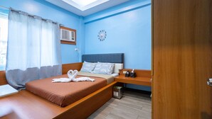 Ein modernes Schlafzimmer mit Bett, Nachttisch, einer Uhr an der Wand und einem Fenster mit Vorhängen.