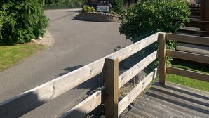 A wooden fence leading to a parking area with a sign for a restaurant. - Feorag Lodge -  Retreat Group (Aviemore)