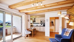 A modern interior with a dining area, kitchen, and seating space. - Ferienwohnung Alpenzauber mit Balkon, ca. 60 qm (Reit im Winkl)