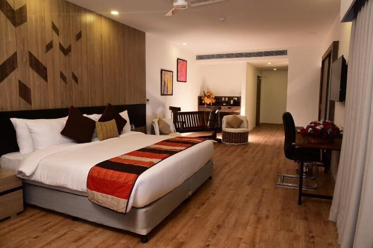 Ein modernes Hotelzimmer mit einem großen Bett, einem Schreibtisch und einem Essbereich.