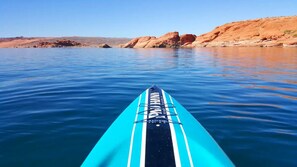 A kayak on calm water with a rocky landscape in the background.