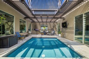 A pool area with a pergola overhead, lounge chairs, and a seating area with a table. - Spacious 5-bedroom retreat with private pool, golf, and mountain views. (Hurricane)
