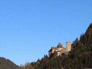 Un château perché sur une colline, sous un ciel dégagé.