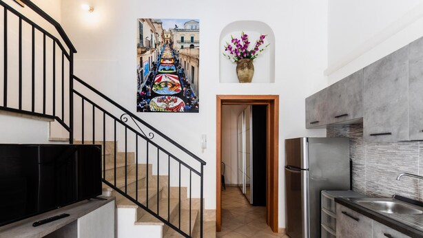A modern kitchen with a stainless steel refrigerator, a built-in oven, and a grey countertop. - Ciuri Ciuri in Noto With 3 Bedrooms and 2 Bathrooms (Noto)