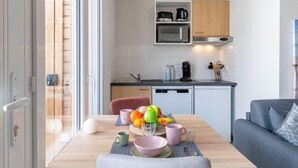 A modern kitchen with a microwave, coffee maker, and utensils on the counter. - Apartment SC H01 by Interhome (Mimizan)