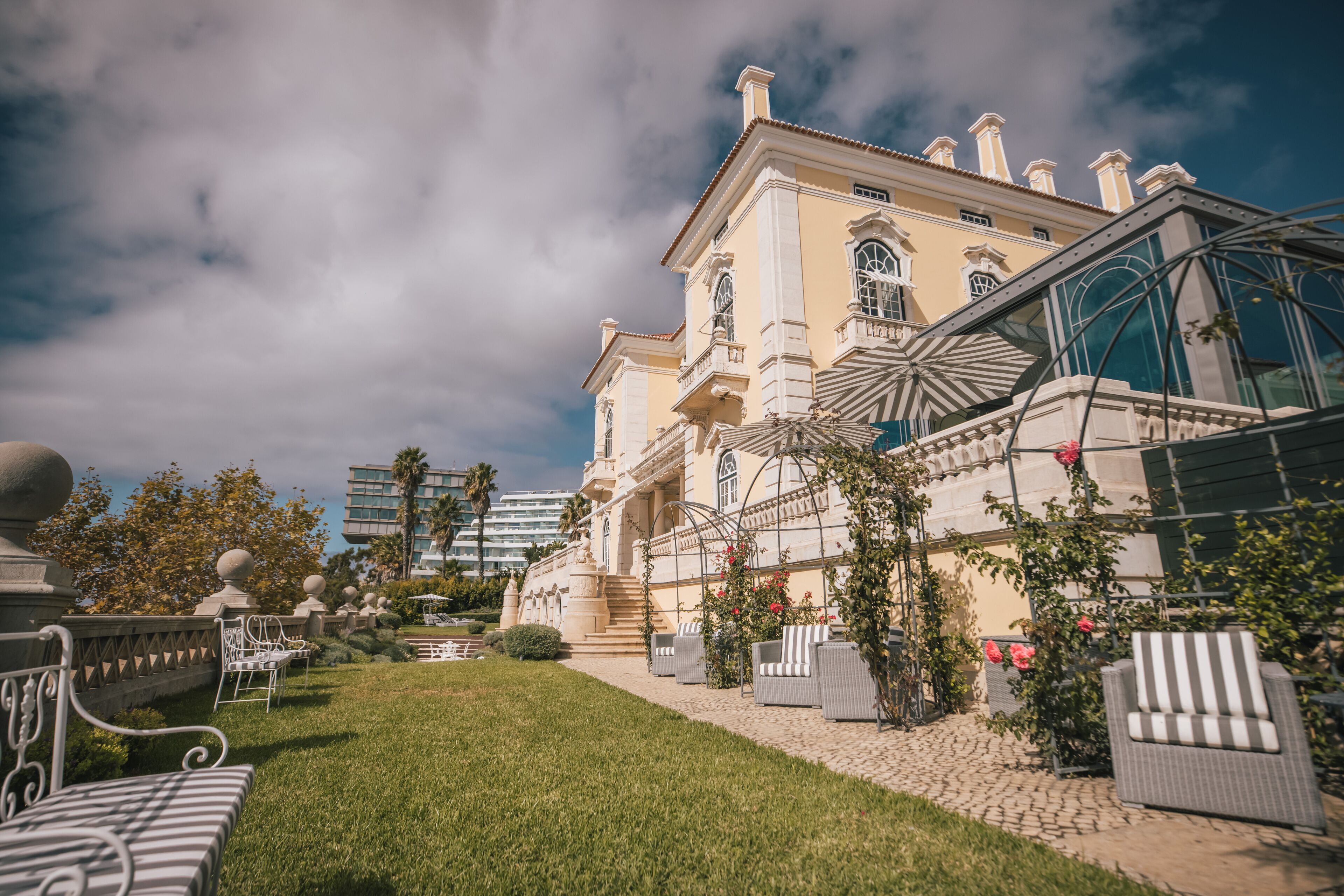 A historic building with a garden patio, outdoor seating, and a glass conservatory.