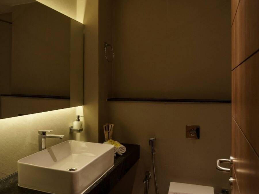 A modern bathroom with a large sink, a toilet, and a shower.