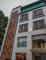 A multi-story building with a modern design, featuring large windows and wooden paneling on the facade.