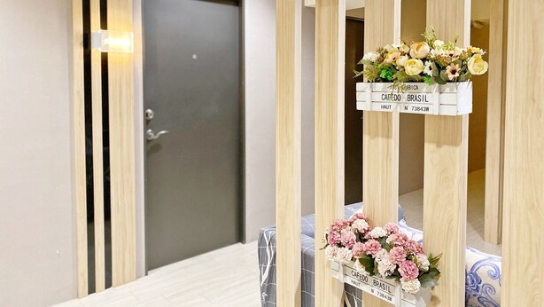 Ein Hotelzimmer mit einer Holzwand, einer Tür und drei Blumenarrangements an der Wand.