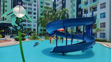 A water park with a blue slide and a green decorative structure.
