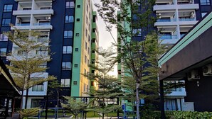 Un immeuble d’appartements moderne, doté de plusieurs étages, d’équipements de fitness en plein air et d’un espace jardin bien entretenu.
