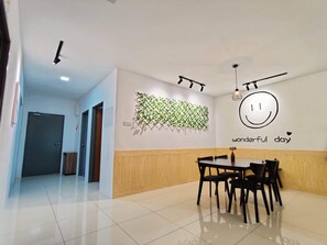 Un espace de restauration moderne avec un mur en bois, une décoration murale représentant un visage souriant et un panneau indiquant « passez une merveilleuse journée ».