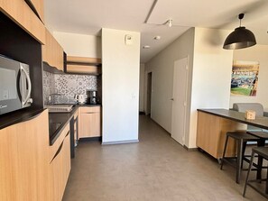 Uma cozinha moderna com micro-ondas, cafeteira e painel de azulejos.