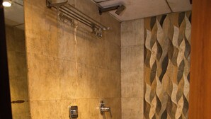 A bathroom with a sink, toilet, and shower. - Hotel Dalon (Mumbai)