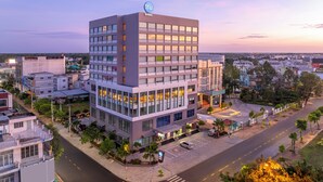 A modern hotel with a prominent Hilton logo, multiple floors, and a well-lit entrance area.