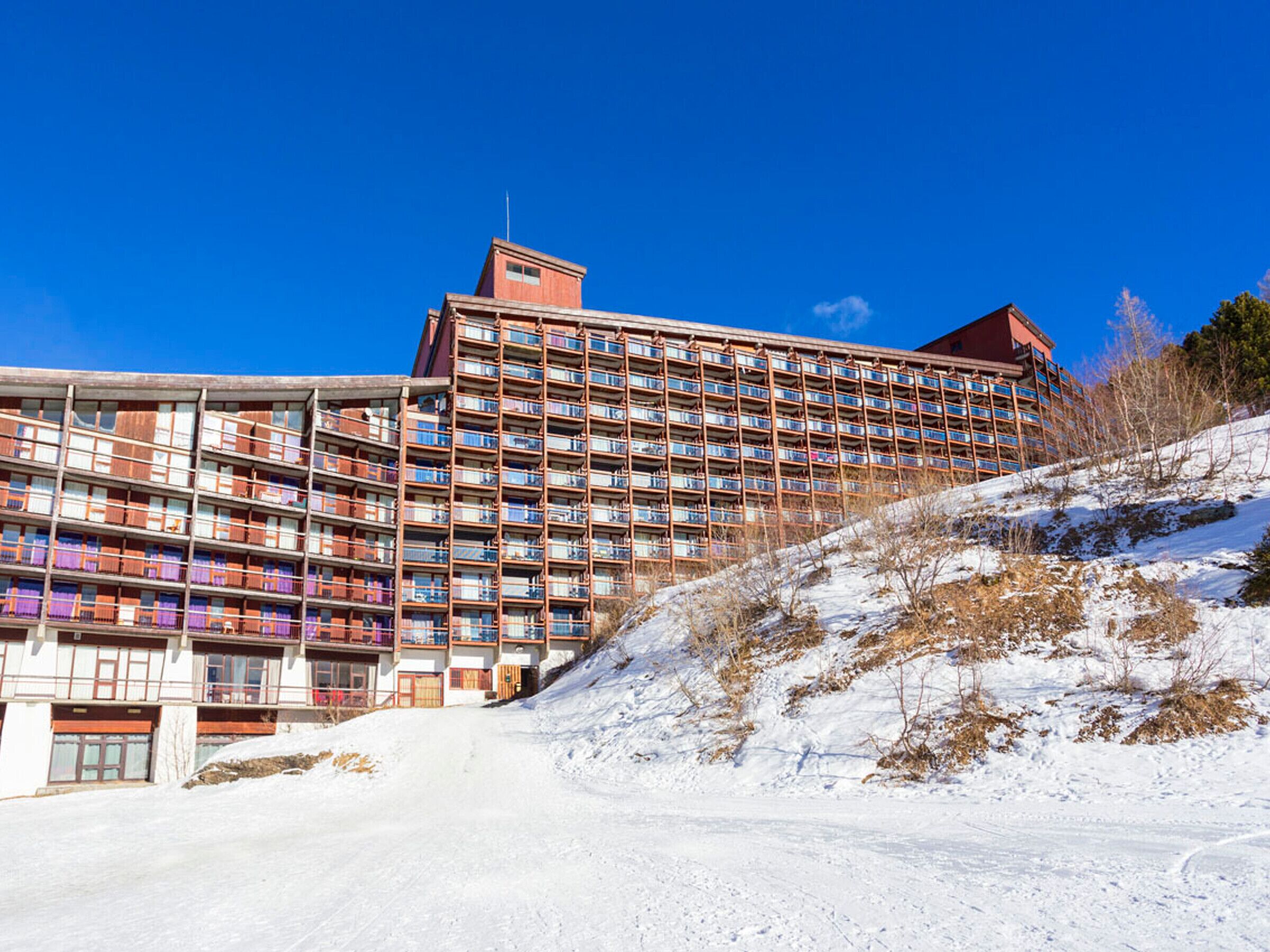 Ein mehrgeschossiges Hotel mit moderner Architektur, mit Balkonen und großen Fenstern.