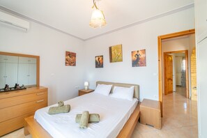 Una camera da letto con un letto, un comodino, una lampada, un'opera d'arte appesa al muro e uno specchio.