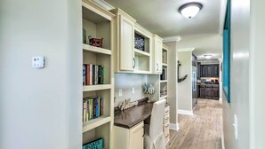 Un interno domestico con cucina, zona pranzo e soggiorno.