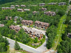 Un complexe touristique comprenant plusieurs bâtiments de style chalet, un télésiège et une route.