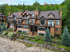 Un immeuble résidentiel à plusieurs étages, doté d’une conception symétrique, de balcons et de grandes fenêtres.
