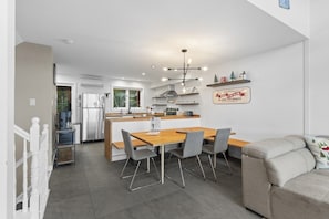 A modern kitchen with a dining area, a coffee machine, and a sign on the wall. - 4 Storey Ski In/Out Mountain Home in Tremblant (Mont-Tremblant)
