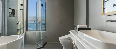 A modern bathroom with a glass-enclosed shower, a large bathtub, and a toilet.