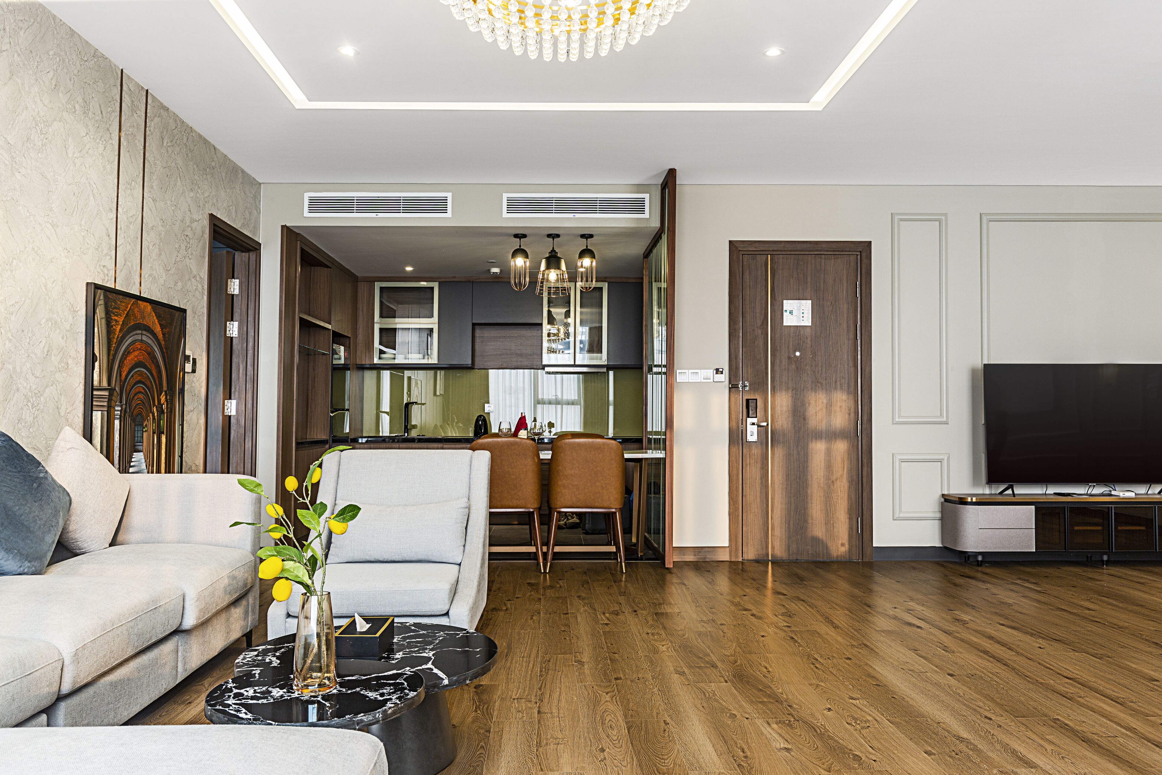 A modern living room with a sofa, coffee table, and a dining area with chairs.