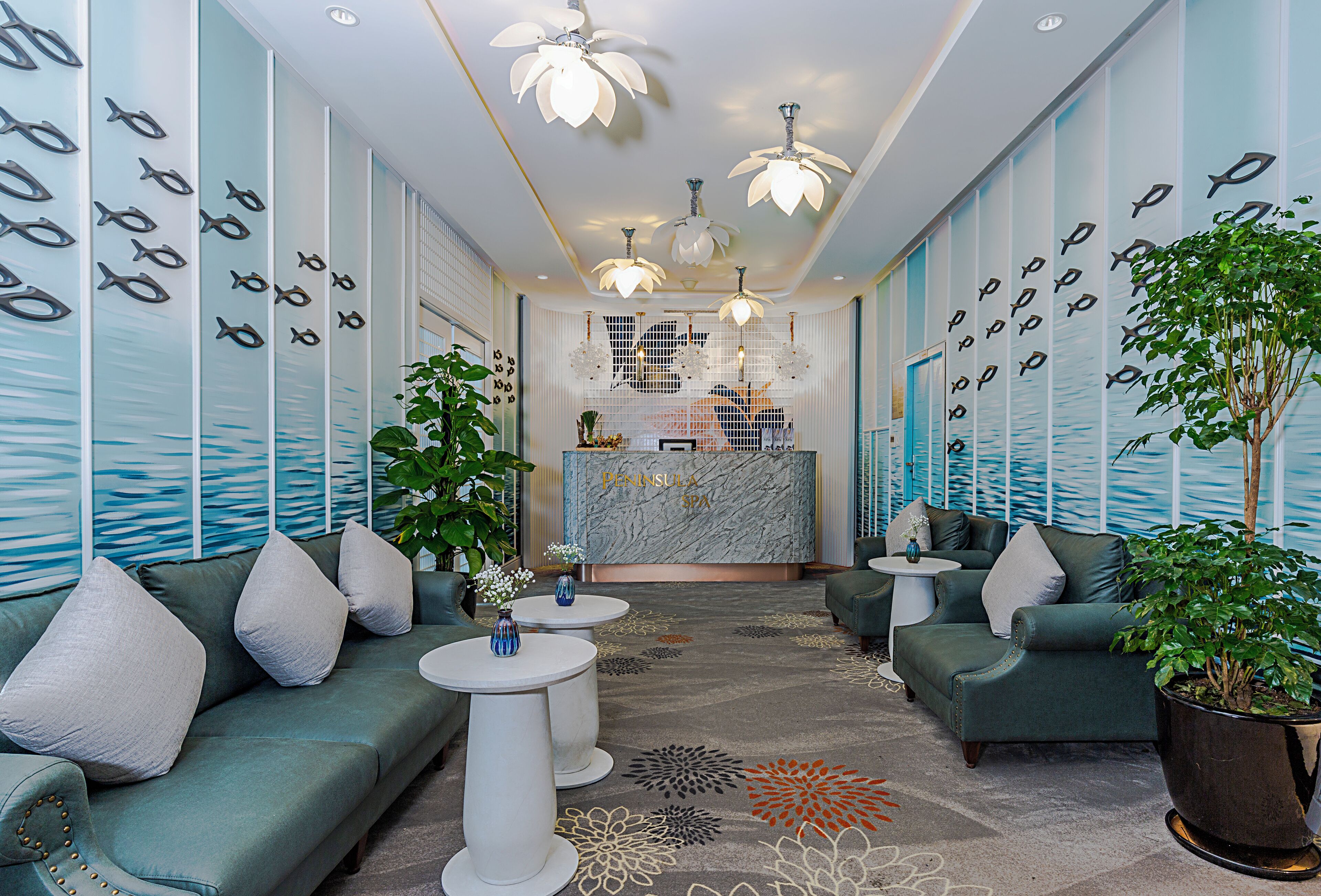 A modern lobby with a reception desk, seating area, and decorative fish wall art.