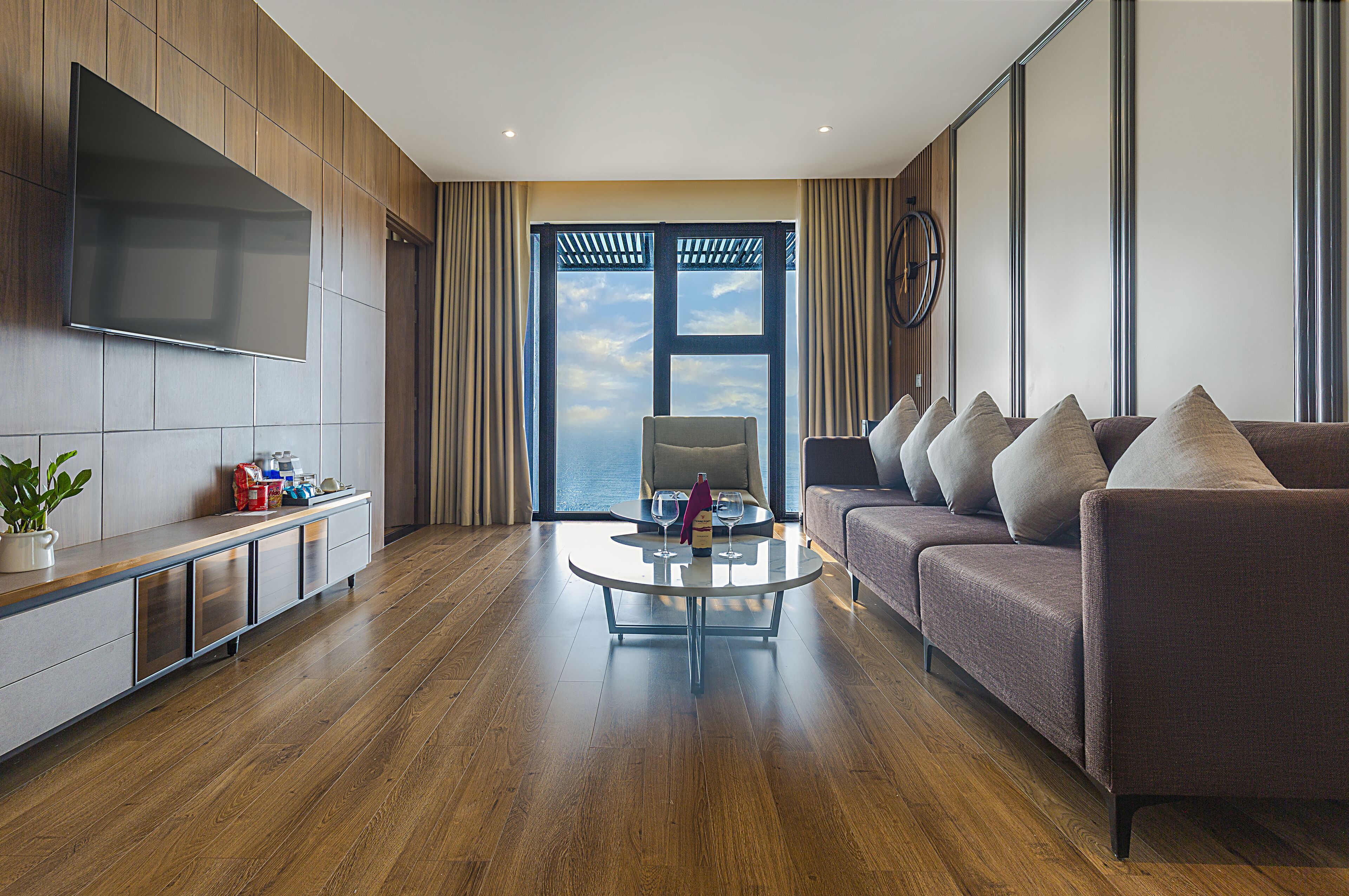 A modern living room with a sofa, a coffee table, and a TV mounted on the wall.