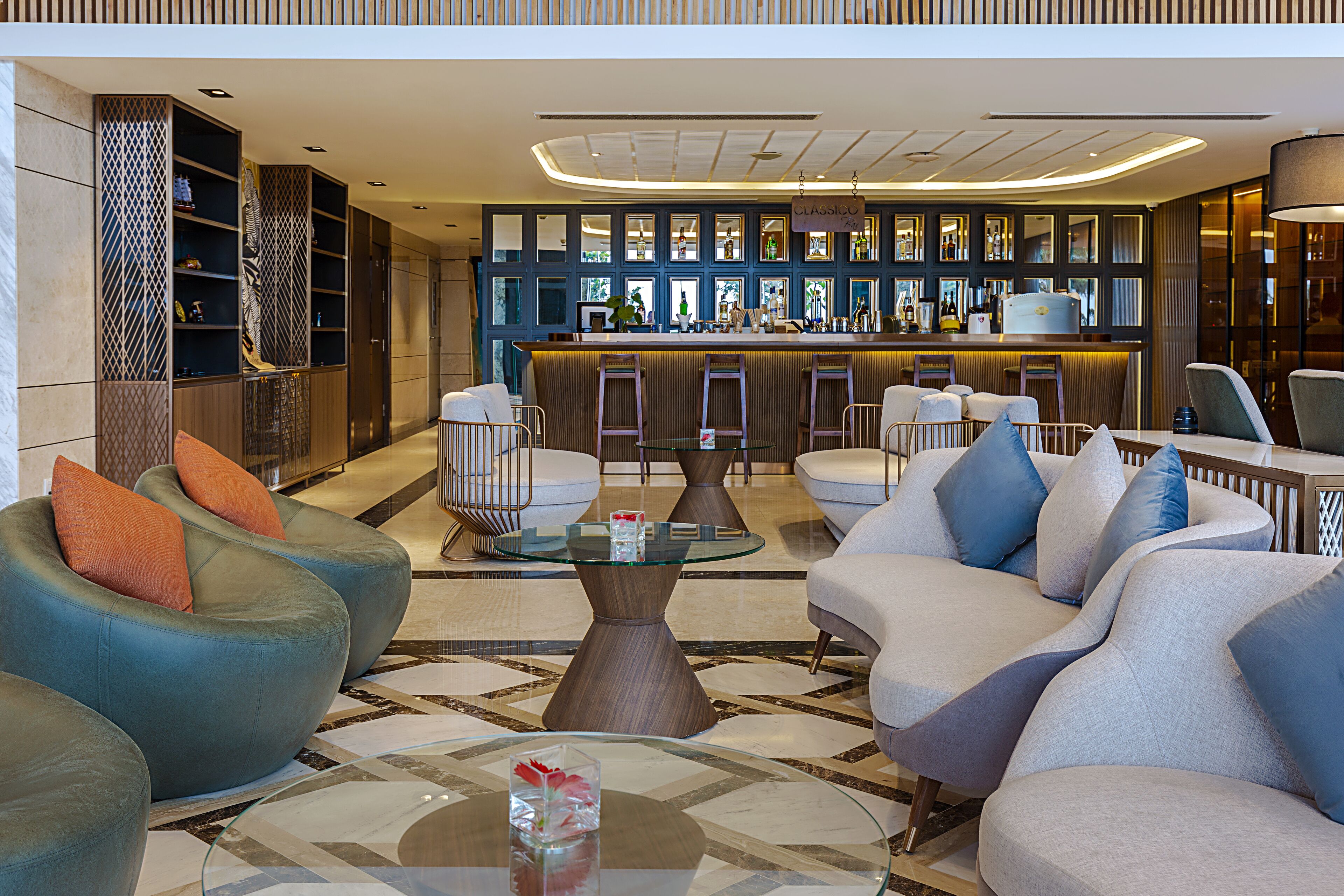 Eine moderne Lobby mit Sitzbereichen, einer Bar und einer Wand mit Regalen.