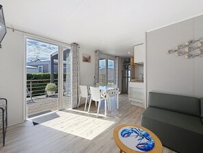 Un appartement moderne doté d’un coin repas, d’une kitchenette et d’un balcon avec vue.